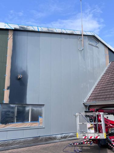 Overspuiten gevelbekleding bedrijfspand Achterberg