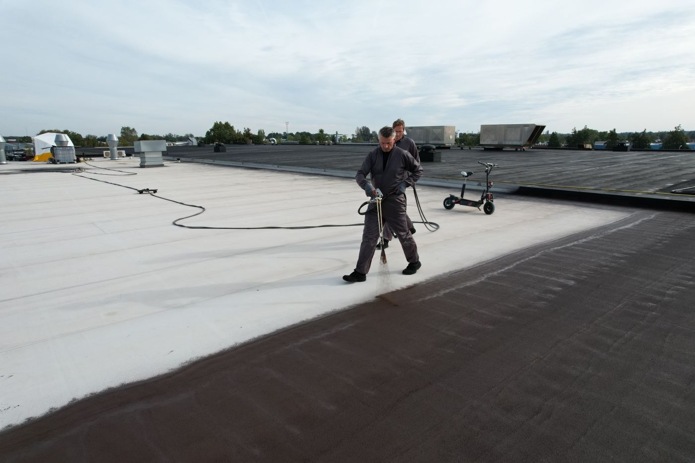 Team van experts brengt vloeibare dakbedekking aan